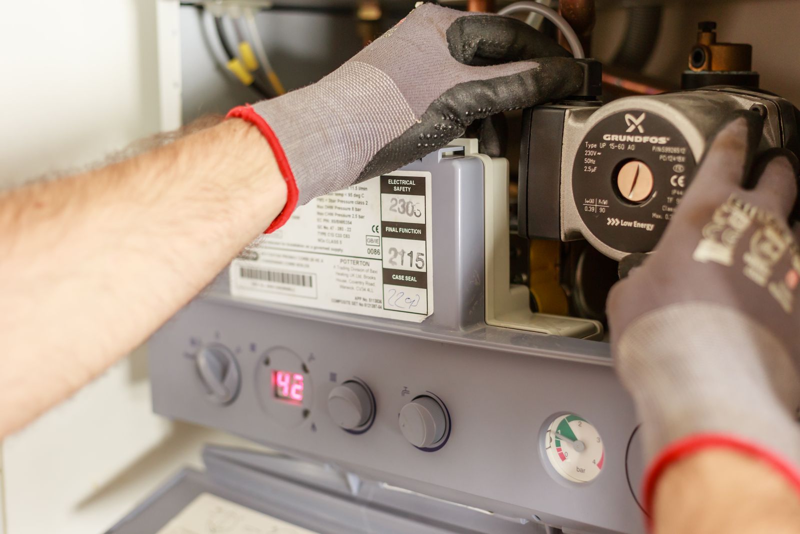 Hands adjusting a water heating system valve