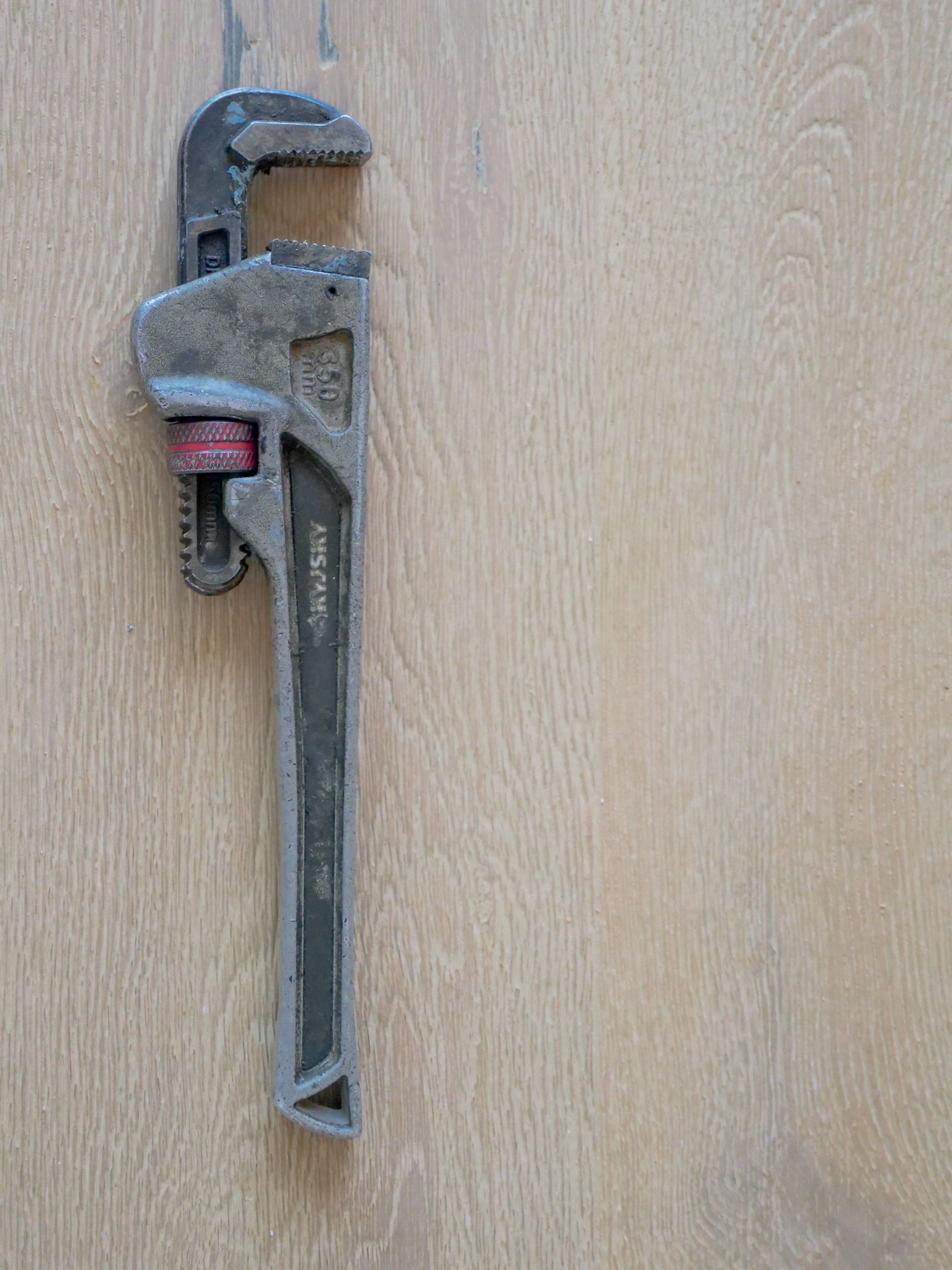 Well-worn pipe wrench on a workbench